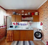 Küche mit Ziegelverkleidung, Holzschränken und Boden mit Holzdekor in einer Vierzimmerwohnung.