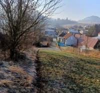 Landschaft in Sklabina mit Grundstücken zum Wohnen, Häusern und Bäumen im Hintergrund.
