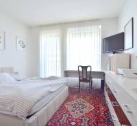 Helles Schlafzimmer mit Sessel, Bett und Teppich in einer 3-Zimmer-Wohnung.