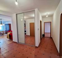 Flur mit Fliesen, Einbauschrank und Eingang zum Wohnzimmer in einer 4-Zimmer-Wohnung.