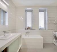 Badezimmer in einer 3-Zimmer-Wohnung mit Dusche, Waschmaschine und Fenstern mit Rollläden.