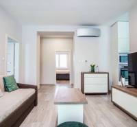 Wohnzimmer in einer 3-Zimmer-Wohnung mit Holzboden und bequemer Couch.