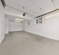 Geräumige Garage in einem Einfamilienhaus mit Fliesenboden und weißen Wänden.