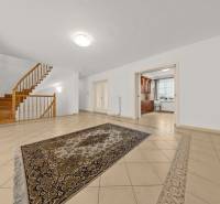 Innenraum eines Einfamilienhauses mit Treppe, Teppich auf Fliesen, geräumige Küche.