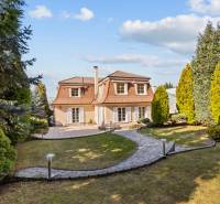 Ein Einfamilienhaus in Bratislava - Záhorská Bystrica mit einem gepflegten Garten und Gehweg.