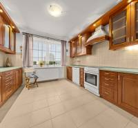 Küche in einem Einfamilienhaus mit Schränken in Holzoptik und Keramikboden.