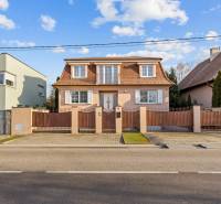 Ein Einfamilienhaus in Bratislava - Záhorská Bystrica mit einem roten Ziegeldach und weißen Fensterläden.