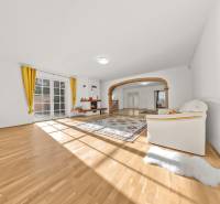 Helles Wohnzimmer mit Holzboden, Kamin und gelben Vorhängen in einem Einfamilienhaus.