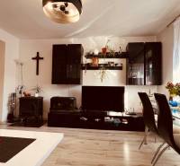 Wohnzimmer einer 3-Zimmer-Wohnung mit Holzboden, Esstisch und Wandregal.