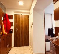 Eingangsflur in einer 3-Zimmer-Wohnung mit Fliesenboden und Holzmuster auf den Türen.