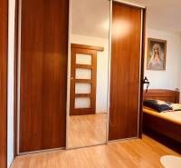 Schlafzimmer in einer 3-Zimmer-Wohnung mit Holzboden, Kleiderschrank und Bild.