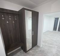 Flur mit Garderobenwand und Spiegel in einem Einfamilienhaus mit Holzboden.