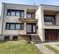 Ein Einfamilienhaus in Zlaté Moravce mit Treppe und Balkon, davor befindet sich ein grüner Rasen.