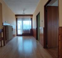 Ein Flur in einem Einfamilienhaus mit einem Boden in Holzoptik und Holzverkleidungen.