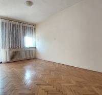 Ein Zimmer in einem Einfamilienhaus mit einem Holzboden und einem großen Fenster.