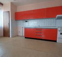 Küche mit roten Schränken, Herd und Fenster in einem Einfamilienhaus.