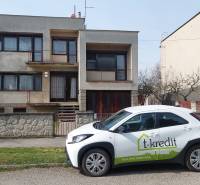 Ein Einfamilienhaus in Zlaté Moravce mit einem vor dem Haus geparkten Auto des Immobilienbüros.