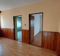 Ein Zimmer in einem Einfamilienhaus mit einem Boden in Holzoptik und einer Wandverkleidung aus Holz.