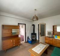 Wohnzimmer in einem Einfamilienhaus mit Holzmöbeln und einem Kachelofen zum Heizen.