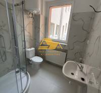 Badezimmer in einer Einzimmerwohnung mit einer Eckdusche und Keramikfliesen.