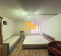 Schlafzimmer in einer 2-Zimmer-Wohnung mit Bett, Schrank und Boden in Holzoptik.