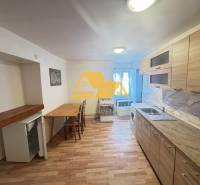 Küche in einer 2-Zimmer-Wohnung mit Holzdekorboden und hellem Mobiliar.