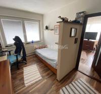 Schlafzimmer mit Bett, Schreibtisch und Boden in Holzoptik, 4-Zimmer-Wohnung.