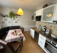 Küche in einer 4-Zimmer-Wohnung mit Eckbank, Keramiktellern an der Wand und Geräten.