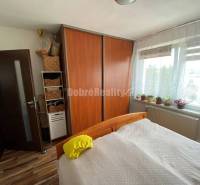 Schlafzimmer in einer 4-Zimmer-Wohnung mit einem großen Einbauschrank und einem Boden in Holzoptik.