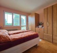 Schlafzimmer mit Bett, Schränken und Holzboden in einer 4-Zimmer-Wohnung.