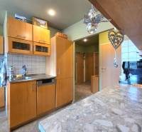 Küche in einer 4-Zimmer-Wohnung mit Holzschränken und einer Stein-Arbeitsplatte.