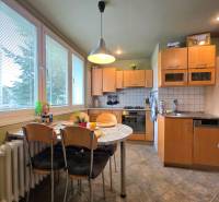 Küche in einer 4-Zimmer-Wohnung mit Eckküche, Esstisch und großen Fenstern.
