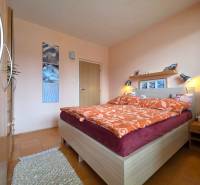 Schlafzimmer mit Doppelbett, Teppich, Holzboden, dekorative Bilder, 4-Zimmer-Wohnung.