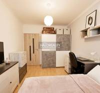 Schlafzimmer in einer 2-Zimmer-Wohnung mit Holzboden und Stauraum.