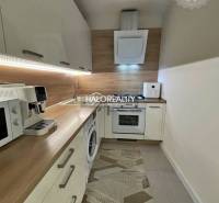 Küche in einer 2-Zimmer-Wohnung mit Holzboden und Geräten.