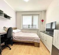 Schlafzimmer in einer 2-Zimmer-Wohnung mit Bett, Schreibtisch und Fernseher. Boden mit Holzdekor.