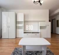 Innenraum einer Ferienwohnung mit weißen Möbeln und Boden in Holzoptik.