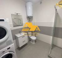 Badezimmer mit Dusche, Waschmaschine und Waschbecken in einer 3-Zimmer-Wohnung.