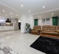 Wohnzimmer in einem Einfamilienhaus mit Sitzgarnitur und Küchenbereich.