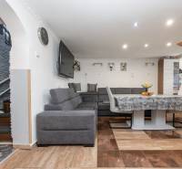 Wohnzimmer mit Ecksofa, Tisch und Holzboden in einem Einfamilienhaus.