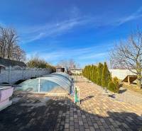 Garten mit Pflastersteinen und überdachtem Pool in einem Einfamilienhaus in Dvorníky.