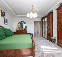 Schlafzimmer mit Holzmöbeln und grüner Bettwäsche in einem Einfamilienhaus.