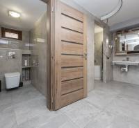 Badezimmer in einem Einfamilienhaus mit Keramikfliesen, WC und Waschbecken.