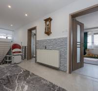 Der Flur in einem Einfamilienhaus mit einer Uhr an der Wand und einem Treppenlift.