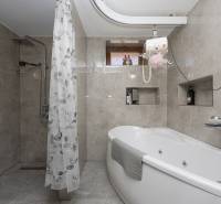 Badezimmer mit Dusche und Badewanne in einem Einfamilienhaus, Wände mit Keramikfliesen.