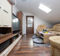 Wohnzimmer mit Sofa, Fernseher und Holzboden in einem Einfamilienhaus.