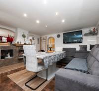 Wohnzimmer in einem Einfamilienhaus mit einem bequemen Sofa und einem Boden in Holzoptik.