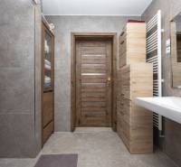 Ein Badezimmer in einem Einfamilienhaus mit Holzdekor und Keramikfliesen.