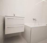 Elegantes Badezimmer mit weißem Waschbecken und Badewanne in einer 2-Zimmer-Wohnung.