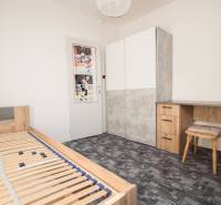 Schlafzimmer in einer 4-Zimmer-Wohnung mit Bett, Schreibtisch und Kleiderschrank.
